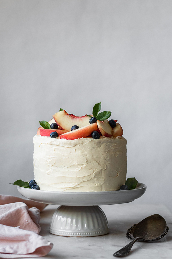 Classic vanilla cake filled with cardamom-spiced peaches and frosted with caramelized white chocolate buttercream.