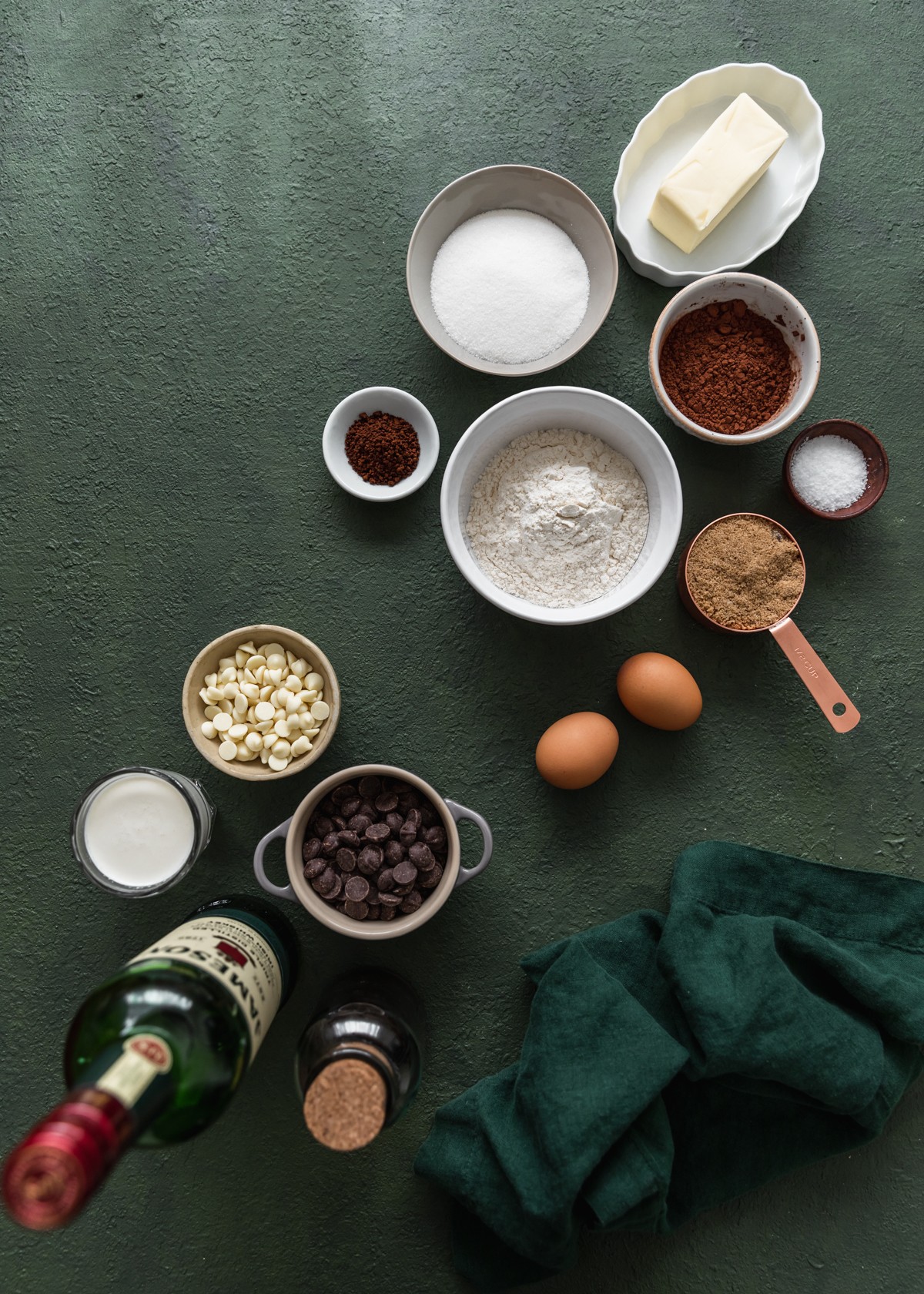 An overhead photo of brownie ingredients on a dark green background.